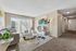 Bright and inviting living room with modern decor, featuring a plush gray sofa, stylish coffee table, and floor-to-ceiling windows with scenic outdoor views.