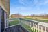 Charming balcony view with lush green surroundings and blue sky, perfect for relaxation and enjoying nature.