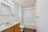 Modern bathroom with sleek vanity, full bathtub, and elegant lighting in a spacious layout.