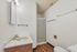 Chic bathroom with modern fixtures, featuring a sleek shower and elegant wood flooring.