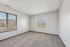 Bright and airy unfurnished room with clean carpet, large windows, and a serene outdoor view, ideal for creating a personalized living space.