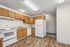 Inviting kitchen with warm wooden cabinets, modern appliances, and stylish hardwood flooring.
