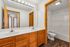 Elegant bathroom boasting a double sink vanity, bright lighting, and rich wooden cabinetry, offering a touch of luxury and functionality.