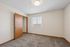 Bright and inviting bedroom with plush carpet, featuring a large window offering natural light and a spacious closet.