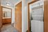 Inviting corridor with plush carpet, featuring in-unit stacked washer and dryer next to a modern bathroom with ample cabinetry.