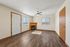 Bright living room with elegant wood flooring, modern ceiling fan, and cozy fireplace, perfect for relaxing and entertaining.