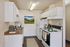 Bright and inviting kitchen with modern appliances, ample cabinetry, and a scenic mountain landscape artwork on the wall.