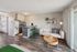 Modern open-concept apartment featuring a cozy living area, sleek kitchen with bar seating, and elegant decor.