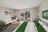 Bright modern living room with sleek furniture, large sliding doors leading to a serene balcony, and a cozy workspace area.