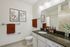 Elegant bathroom with modern fixtures, featuring a sleek granite countertop and stylish wall art.