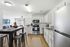 Bright and modern kitchen with sleek stainless steel appliances, elegant white cabinetry, and a cozy open-concept living space with stylish decor.