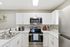 Modern kitchen with sleek stainless steel appliances, white cabinetry, and elegant countertops offering a stylish and functional cooking space.