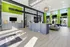 Modern apartment lobby with vibrant green accents, sleek reception desks, and natural lighting.