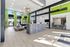 Modern apartment lobby featuring sleek design with vibrant green accents, comfortable seating, and a welcoming reception area.