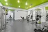 Modern gym with vibrant green accents, featuring state-of-the-art equipment for a complete workout experience.