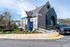 Charming leasing office with modern architecture, vibrant landscaping, and easy parking access at a premium residential area.