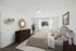 Bright and elegant bedroom with modern decor, featuring a plush bed, large window with lush view, and stylish furnishings.