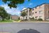 Charming apartment complex with classic brick facade, lush landscaping, and inviting entrance surrounded by greenery.