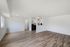 Bright and modern open-concept living space with sleek wooden flooring and a minimalist kitchen design.