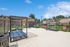 Inviting outdoor lounge area with modern reclining chairs, set against a backdrop of well-maintained lawns and charming brick apartment buildings.