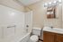 Bright and inviting bathroom featuring a clean white tub, modern vanity with ample storage, and elegant lighting. Perfect for relaxation.
