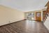 Inviting living room with elegant wood-style flooring, large windows for natural light, and modern finishes, perfect for comfortable living.