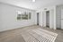 Bright, spacious bedroom with large window, plush carpet, and ample closet space in a modern apartment.