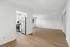 Bright open-concept apartment with sleek wooden floors, a modern stainless steel kitchen, and ample natural light.