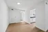Bright and airy apartment interior featuring sleek wood flooring and a modern kitchen with white cabinetry.