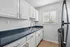Bright and modern kitchen featuring sleek white cabinets, elegant countertops, and a stainless steel oven.