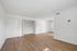Bright and spacious room with sleek hardwood floors, open closet, and ample wall space for creative design.
