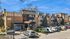 Modern apartment complex showcasing stylish architecture and ample parking, set against a clear blue sky.
