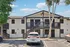 Charming apartment exterior with modern black and white design, surrounded by lush trees and ample parking space.