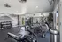 Modern fitness center with state-of-the-art gym equipment, mirrored walls, and mountain mural backdrop for an invigorating workout experience.