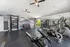 Bright and modern home gym with sleek exercise equipment, mirrored wall, and scenic mountain mural for a motivating workout space.