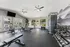 Bright and modern gym featuring state-of-the-art equipment, including treadmills, exercise bikes, and free weights, with large windows offering a scenic view.
