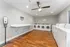 Bright and spacious laundry room with modern washers and dryers, wood flooring, and ample folding space.