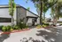 Inviting leasing office facade surrounded by lush greenery and ample parking, perfect for prospective renters.