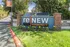 Inviting entrance of reNEW Summit Apartments surrounded by lush greenery and colorful flowers, showcasing a warm and welcoming atmosphere.