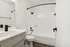 Sleek modern bathroom with elegant white finishes, featuring a stylish black faucet and shower fixtures.