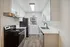 Modern kitchen with sleek stainless steel appliances, elegant white cabinetry, and luxurious marble countertops, featuring stylish wood flooring and ample natural light.