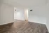 Bright and spacious living area with elegant wood flooring and contemporary ceiling fan, perfect for a cozy home ambiance.