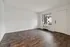 Bright living area with stylish wood flooring and a large window, ideal for natural light.
