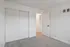Bright and airy bedroom with plush carpet flooring and a spacious closet, perfect for modern living.