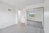 Bright bedroom with plush carpeting and mirrored closet doors, showcasing a sunny window view.