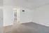 Bright and airy apartment interior with fresh carpet, white walls, and a glimpse into a sunlit room.