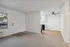 Inviting apartment interior showcasing a cozy carpeted living area and a sleek, modern kitchen with stylish hardwood floors.