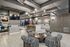 Modern apartment lounge with chic zebra-patterned seating, stylish lighting, and a sleek kitchen with marble island and geometric backsplash.