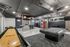 Modern recreational room featuring sleek pool table, shuffleboard, vending machines, and stylish seating area.