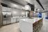 Contemporary kitchen featuring sleek stainless steel appliances, elegant white cabinetry, and a spacious marble island with modern lighting.